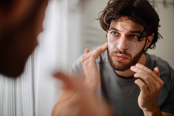 istock Handsome Young Man Applying Face Cream 1394950874