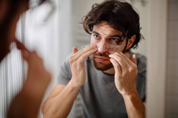 istock Handsome Young Man Applying Face Cream 1394950881
