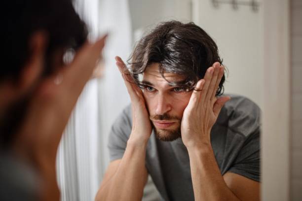 istock Man applying serum to his face 1394951446