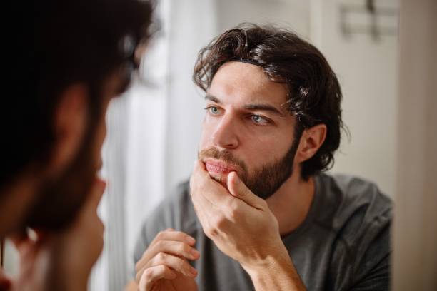 istock Man applying serum to his face 1394951459