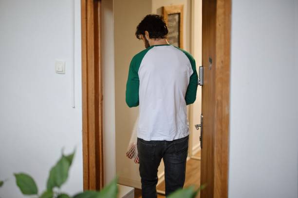 istock Man coming home with reusable grocery bags 1394951651