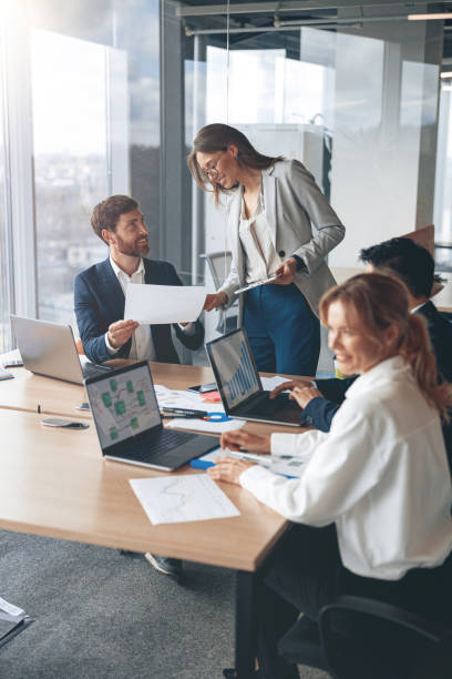 istock Beautiful business people are using gadgets, talking and smiling during the conference in office 1394952077