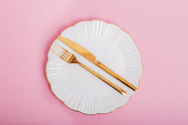 istock White plate with golden knife and fork 1394954910
