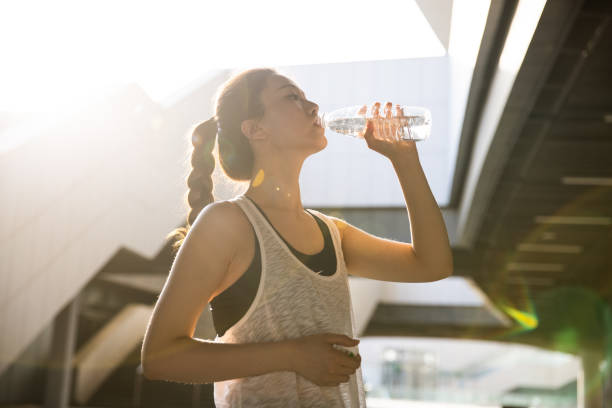 istock young woman drinking water after sport 1394956029