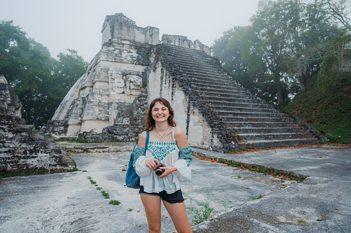 Young Caucasian woman photographing in  Tikal National Park