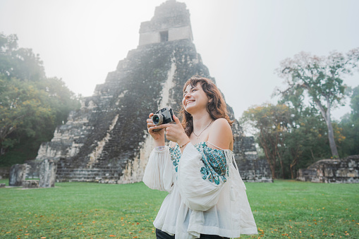 Young Caucasian woman photographing in  Tikal National Park