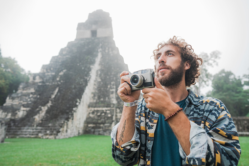 Young Caucasian man photographing in  Tikal National Park