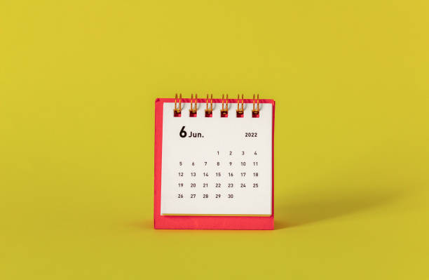 istock Desktop mini calendar for June 2022 on a yellow background. 1394964151