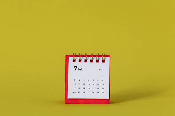 istock Desktop mini calendar for July 2022 on a yellow background. 1394964155