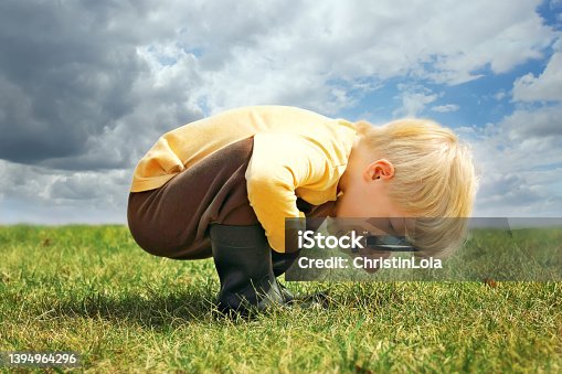 istock Little Boy Exploring Nature Outside with Magnifying Glass 1394964296