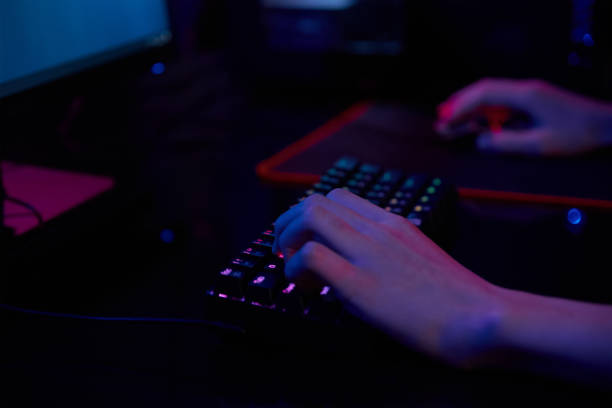 istock Gamer play computer game, use rgb neon colored keyboard 1394965544