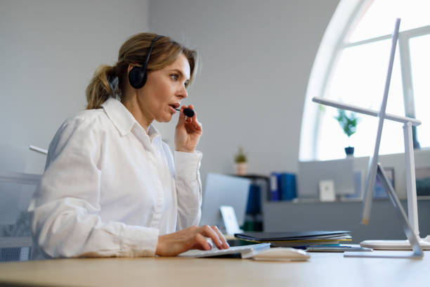 istock Beautiful female call center operator working on computer in office. Helpline employee 1394965708