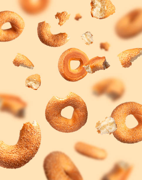 istock Creative food, baking layout. Fresh round wheat bagel with sesame seeds flying on beige background. Crispy bread, healthy organic food, traditional pastries, bakery product. Breakfast bagel 1394966801