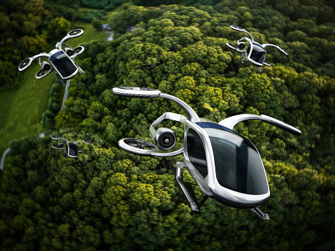 Conceptual eVTOL (electric vertical take-off and landing) aircrafts flying against a dense forest background.