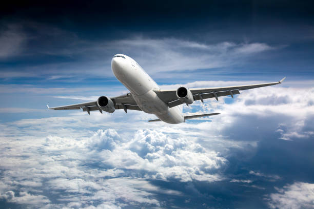 istock Passenger plane flies high in the blue sky above the clouds. Front view. 1394969650
