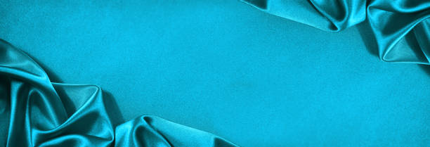 istock Beautiful light green blue silk satin surface. Soft folds on shiny fabric. Luxury teal background with space for text, design. Web banner. Wide. Panoramic. 1394970314