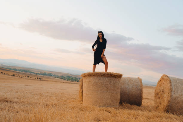 Happy young woman among rye field. Summer Girl enjoying nature on yellow field.