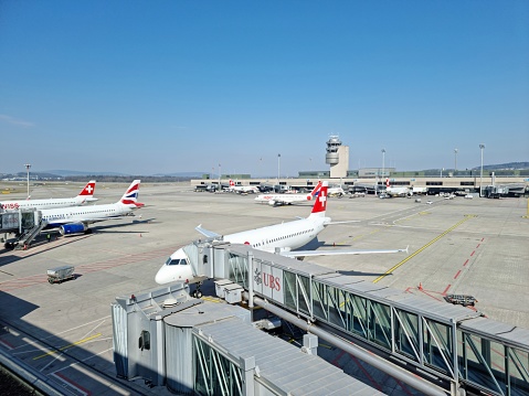 Airport Zurich ZRH with Airfield between the Gates.  Zurich Airport offers scheduled and charter flights to 203 destinations in 67countries. The Image was captured during spring season and shows several aircrafts at the gate.