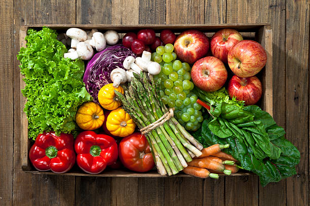 деревянный ящик, полной фруктов и овощей на деревенском таблица - basket of fruits стоковые фото и изображения