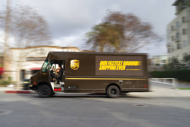 conduite de camionnette de livraison ups - united parcel service truck shipping delivering photos et images de collection