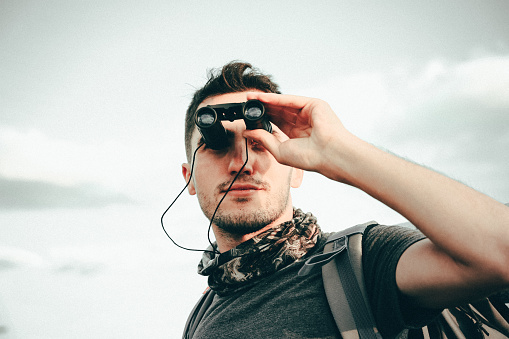 Young confident explorer looking through the nature.