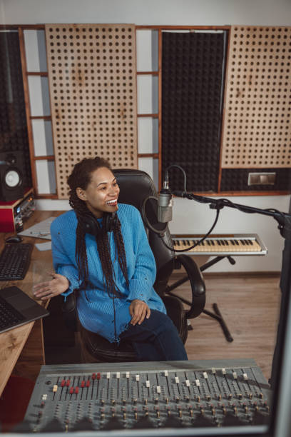 istock Charming African woman radio presenter talks into microphone while broadcasting interesting program in recording studio 1394980433