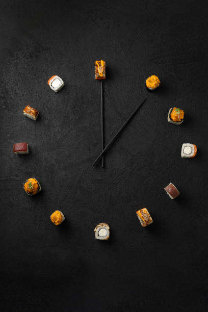 Time to have a snack with Japanese sushi rolls on a black background