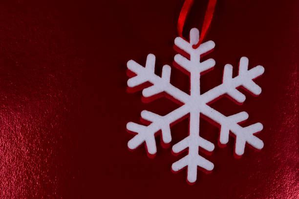 White snowflake on a red shiny christmas background.