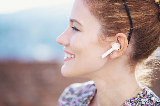 istock Young redhead woman calling by hands free device closeup 1394981844
