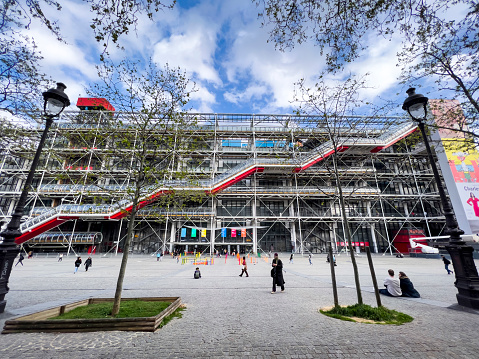 Paris, France - April 7, 2022: The exterior of the Center Georges Pompidou in Paris, France. Inside it features the public library and the Museum of Modern Art. The sloping square serves as a recreation and entertainment area for visitors, tourists and local residents.