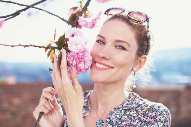 istock Happy young woman holding cherry blossom 1394982588