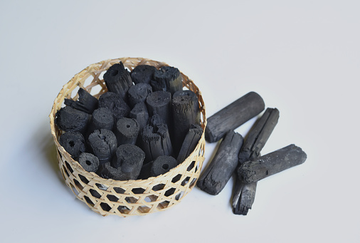 bamboo charcoal in the basket isolates on white background .