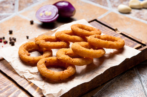 Roasted onion rings on a wooden plate Onion rings are famous as a beer snack fried onion rings stock pictures, royalty-free photos & images