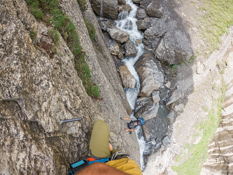 Wide angle view of sporty man climbing in summer on Via Ferrata in Switzerland