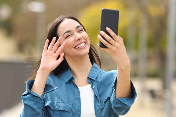 Happy woman greeting having videocall on phone stock photo