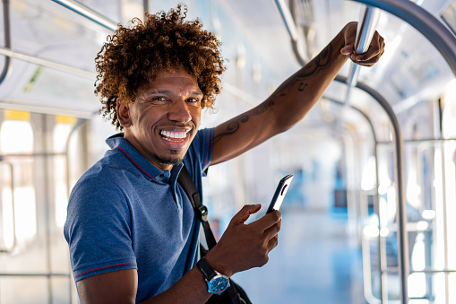 Man on subway train using smartphone