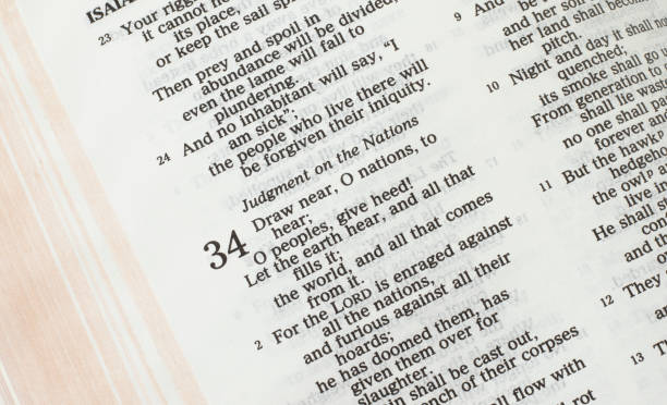 istock Judgment on the nations, biblical text verses in open Holy Bible Book, prophet Isaiah 34 1394990875