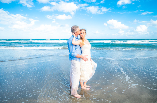 Couple on a scenic beach on their wedding day, a beach wedding or elopement