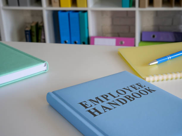manual de funcionários azul na mesa do escritório. - occupation handbook human resources recruitment - fotografias e filmes do acervo
