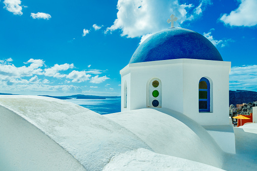 Orthodox church with blue dome in village Oia (Ia) on Santorini island.