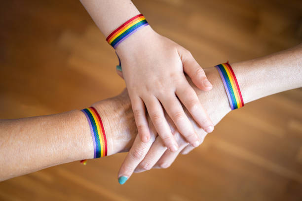 istock Three hands with LGBT flag bracelets. LGBT pride movement 1394994590