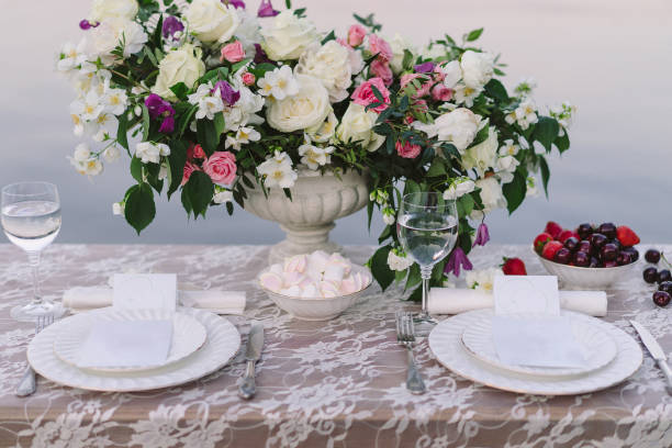 istock Decorated table with flower composition, fruits and marshmallows served for two people. 1394996256