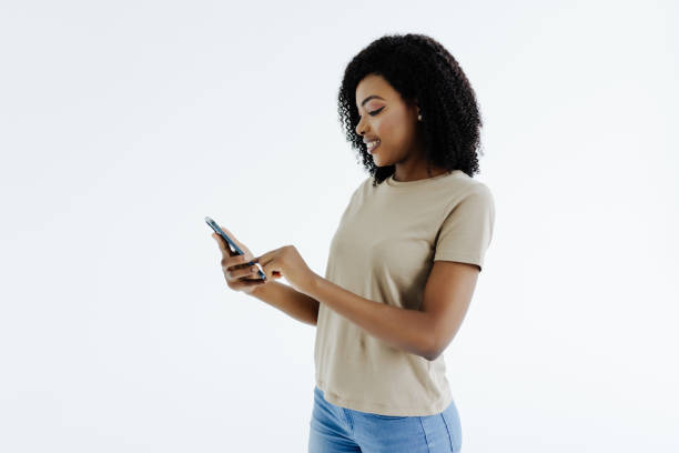 istock African woman smiling while using her phone texting with smartphone isolated on white background 1394996954