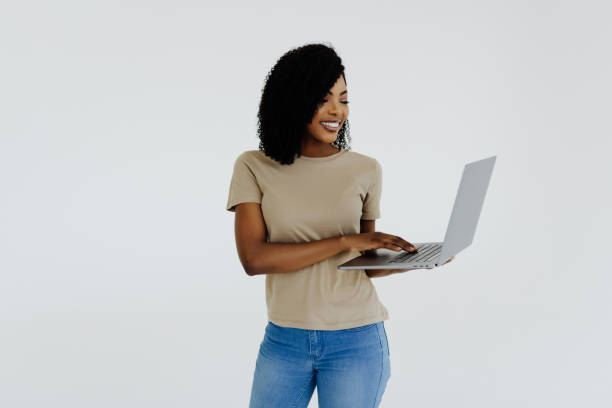 istock Happy afro woman using laptop isolated over white background 1394998257