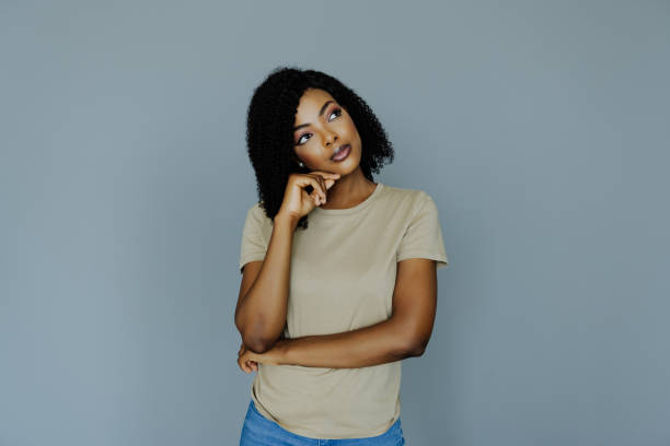 istock Young african woman thinking isolated on gray background 1394999074