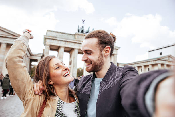 casal tira uma foto de sua última viagem - brandenburg gate berlin germany gate germany - fotografias e filmes do acervo