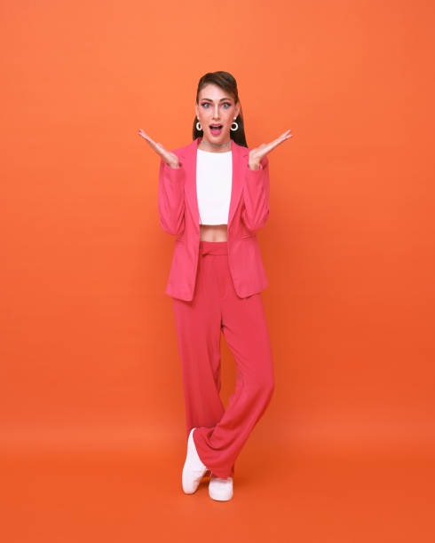 istock Surprised young woman over orange background. 1395003104