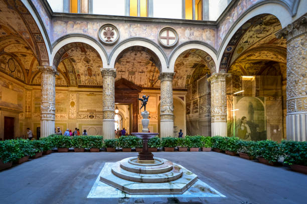 Inner courtyard of Palazzo Vecchio - town hall of Florence, Italy Inner courtyard of Palazzo Vecchio - town hall of Florence, Italy, with antique frescoes and the fountain with the statue of the Putto with dolphin by Andrea del Verrocchio palazzo vecchio stock pictures, royalty-free photos & images