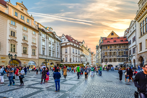 Tourists crowd the picturesque Old Town Square and gather near the Astronomical Clock as they enjoy the many shops and cafes in the historic center of Prague, Czechia