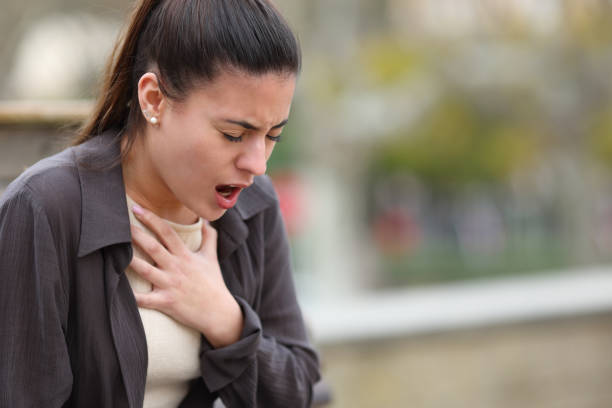 Stressed woman having problems to breath in a park stock photo
